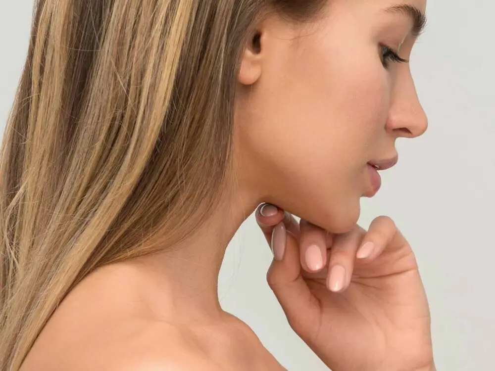 Eine Frau hält sich ein Maßband um ihren Bauch