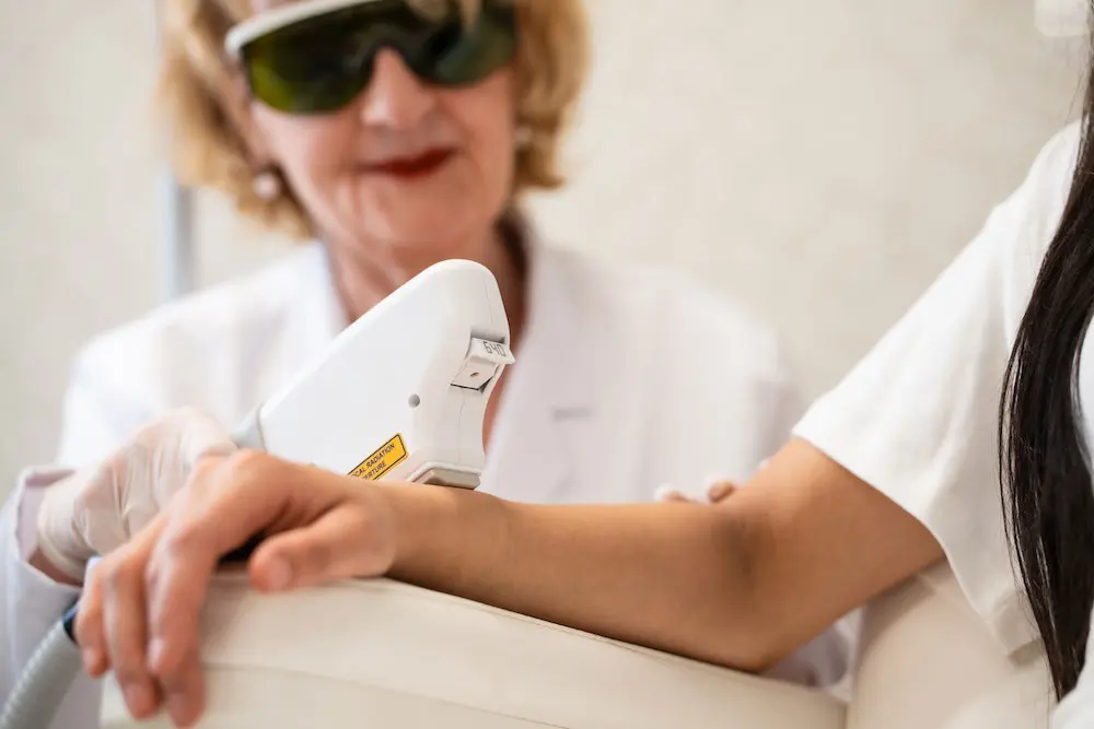 Ipl Haarentfernung Der Arm einer Frau wird mit dem IPL-Gerät behandelt